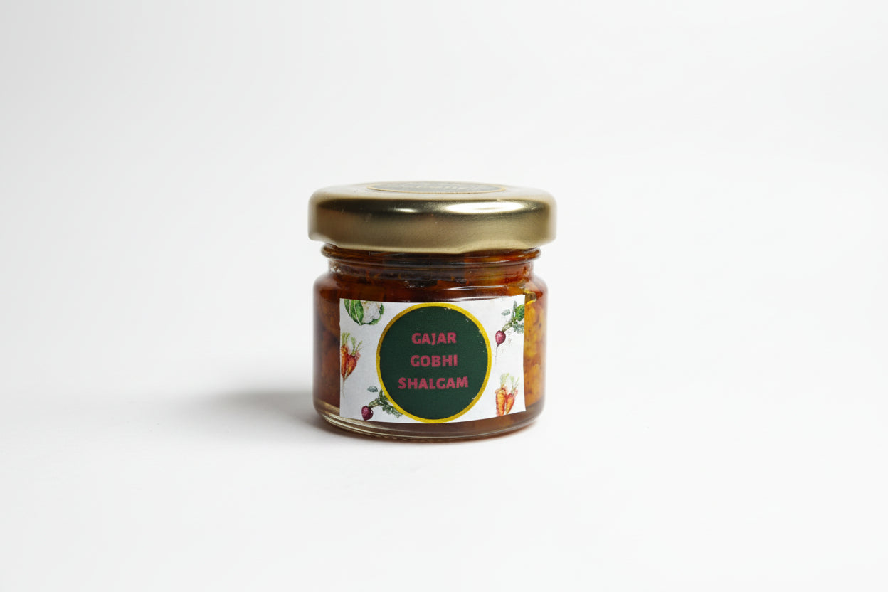 Small jar of gajar gobhi shalgam on a white surface with a blurred background